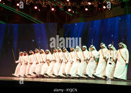 Dubai, Emirati Arabi Uniti - Dicembre 3, 2017: un gruppo di tradizionalmente condita uomini esecuzione di Ayala danza (stick dance) che è parte integrante del patrimonio Emirati. Foto Stock