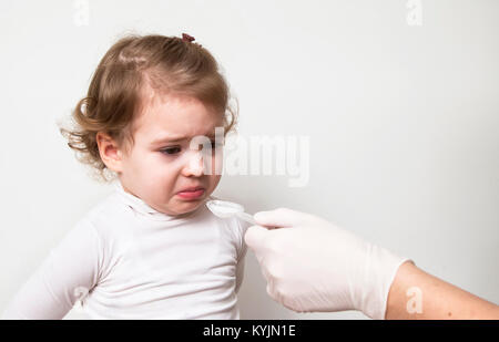 Little Baby girl assunzione di medicina con cucchiaino Foto Stock