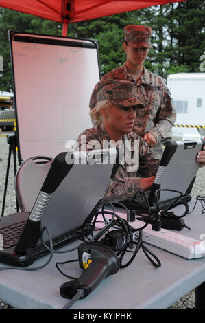 Kentucky esercito nazionale Guard PFC. Rachel Hardin, chimico, biologico, radiologico e nucleare (CBRNE) Specialista assegnato al 299i Chemical Company e Kentucky Air National Guard Master Sgt. Dana Tingle, un Evacuee Tracking e sistema di responsabilità (ETA) operatore, via pazienti intitolata al trattamento medico strutture Giugno 8, 2016 durante la Cascadia Rising esercizio presso il Camp Rilea, Oregon. Cascadia Rising simula un 9.0-terremoto di magnitudine lungo la Cascadia zona di subduzione, che esegue il test di Oregon e Kentucky Guardia Nazionale CBRNE Dell Enhanced Response Force Package (CERFP) abili Foto Stock