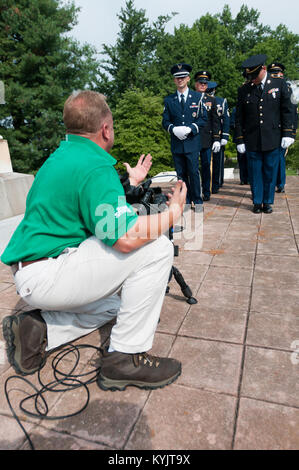 Un CBS Sports videografo germogli di filmati di un comune servizio di guardia di colore Team composto del Kentucky aria Esercito e guardia nazionale i membri a Francoforte il cimitero di Francoforte, Ky., il 5 agosto 2014. Il spot televisivo è stato trasmesso durante la connessione della rete a copertura nazionale di Professional Golfers' Association of America campionato al Valhalla Golf Club a Louisville, KY., Agosto 4-10. (U.S. Air National Guard foto di Master Sgt. Phil Speck) Foto Stock