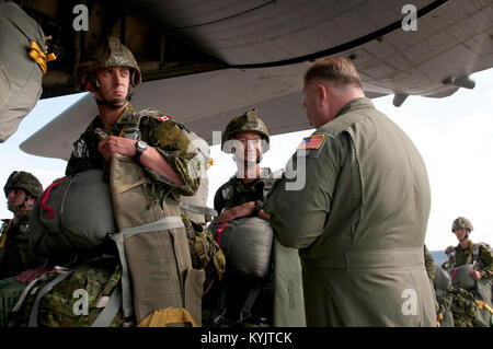 Air Force Master Sgt. Wayne Reeser (a destra), un loadmaster dal Kentucky Air National Guard's 123Airlift Wing, colloqui con un paracadutista dal Royal Canadian Regiment a Ramstein Air Base, Germania, appena prima di un Kentucky C-130 Hercules trasporti aerei il paracadutista e di altre forze della NATO nella regione del Mar Baltico sett. 5, 2014, come parte dell'operazione di giunzione Sabre.. Il Kentucky Air National Guard è che partecipano al funzionamento insieme ad altri cinque Air National Guard di unità e forze da 17 paesi della NATO. (U.S. Air National Guard Photo da 2 Lt. James W. Killen/rilasciato) Foto Stock