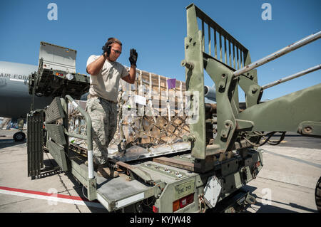 Stati Uniti Air Force Tech. Sgt. Brian Leach, una antenna porter del Kentucky Air National Guard 123della risposta di emergenza Gruppo, dirige il posizionamento di un carrello elevatore a forche per pallet offload di aiuti umanitari da un Halverson la movimentazione del carico veicolo a Léopold Sédar Senghor International Airport di Dakar in Senegal, nov. 12, 2014. Il carico sarà di scena in Senegal prima di essere transloaded NEGLI STATI UNITI. Air Force C-130J di aeromobili per la erogazione in Monrovia, Liberia, a sostegno di operazioni di assistenza unita, U.S. Agenzia per lo Sviluppo Internazionale-led, tutta di sforzo del governo per contenere il virus di Ebola Foto Stock