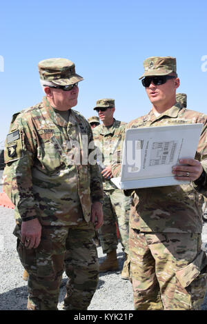 Il personale Sgt. Giacobbe Reckner con il 207th orizzontale di società di costruzioni , a destra mostra i dettagli di un progetto del sito di Brig. Gen. Benjamin Adams III, Kentucky il direttore del personale comune, Mar. 4 a Camp Arifjan in Kuwait. Foto Stock