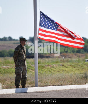 Il personale Sgt. Daniel Dornbusch, 149impegno militare Team, è pronta a sollevare la bandiera americana durante l'esercizio steppa Eagle 17 cerimonia di apertura luglio 22, 2017 a Illisky Training Center, il Kazakistan. Esercizio steppa Eagle è una multinazionale premier è stata incentrata sul mantenimento della pace e nelle operazioni di sostegno della pace, mentre la costruzione di rapporti e della reciproca comprensione tra le nazioni partner. Foto Stock