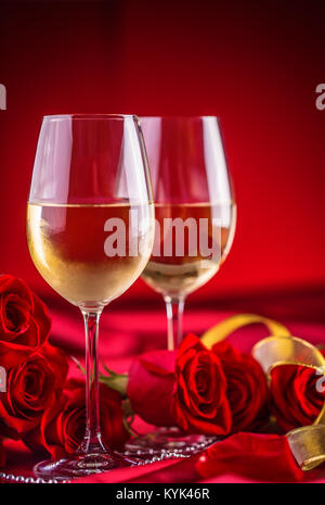 Valentines o il concetto di matrimonio. Bicchieri di vino rose rosse e romantico per due in rosso. Biglietto di auguri per il giubileo o anniversario. Foto Stock