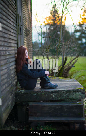 Ragazza seduta sulle porte Foto Stock