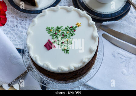 Torta di frutta decorata sulla parte superiore con del marzapane e glassa reale e impresse albero di Natale. Foto Stock