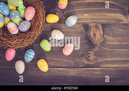 Coloeful uova di pasqua in ordinate sul listone in legno con sfondo spazio. Foto Stock