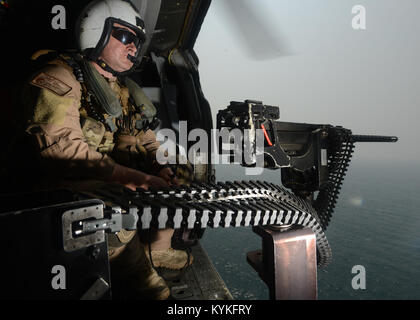 Golfo Arabico (Agosto 20, 2017) Naval Air Crewman (elicottero) Erik Potter mans un .calibro 50 mitragliatrice a bordo di un MH-60S Sea Hawk elicottero assegnato al "Eightballers" di elicottero di mare squadrone di combattimento (HSC) 8 durante le operazioni di routine con la portaerei USS Nimitz CVN (68) nel Golfo Arabico. Nimitz è distribuito negli Stati Uniti Quinta Flotta area di operazioni a sostegno di funzionamento inerenti a risolvere. Mentre in questa regione, la nave e il suo supporto strike gruppo stanno conducendo le operazioni di sicurezza marittima per rassicurare gli alleati e partner, preservare la libertà di navigazione e di mantenere la libera f Foto Stock