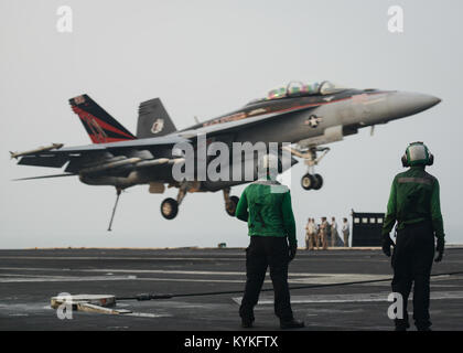 Golfo Arabico (Agosto 22, 2017) gli avieri re Quinton, sinistra, e fiori Quion guardare come un F/A-18F Super Hornet assegnato al "cavalieri neri" di Strike Fighter Squadron (VFA) 154 si prepara a terra a bordo della portaerei USS Nimitz CVN (68) nel Golfo Arabico. Nimitz è distribuito negli Stati Uniti Quinta Flotta area di operazioni a sostegno di funzionamento inerenti a risolvere. Mentre in questa regione, la nave e il suo supporto strike gruppo stanno conducendo le operazioni di sicurezza marittima per rassicurare gli alleati e partner, preservare la libertà di navigazione e di mantenere il libero flusso di commercio. (U.S. Foto di Marina di Massa Co Foto Stock