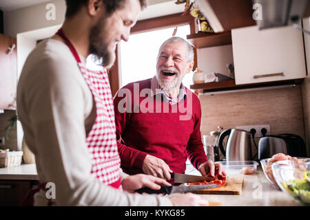 Hipster figlio con il suo anziano padre la cucina in cucina. Foto Stock