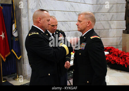 Il Mag. Gen. Stephen Hogan luoghi nuovo ramo insegne sul Chief Warrant Officer Dwight Harlan uniforme durante un cambio di responsabilità a Francoforte, Ky., Dic 20, 2017. (U.S. Esercito nazionale Guard photo by Staff Sgt. Scott Raymond) Foto Stock