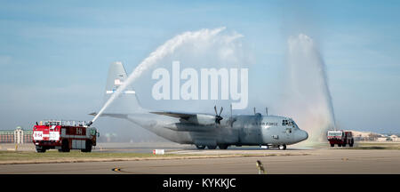 Camion fuoco spruzzare un simbolico omaggio al Kentucky Air National Guard Base in Louisville, KY., come un C-130 Hercules velivolo pilotato da Lt. Col. Scott Wilson taxi al proprio posto di parcheggio nov. 20, 2013. Wilson, che è impostato al ritiro 31.01, 2014, è stato completato il suo finale, o "fini", il volo in C-130. (U.S. Air National Guard foto di magg. Dale Greer) Foto Stock