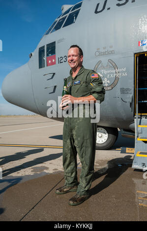 Lt. Col. Scott Wilson, un C-130 pilota in 123Airlift Wing, sorge dall'equipaggio porta del suo aereo al Kentucky Air National Guard Base in Louisville, KY., dopo essere stato irrorato con acqua e champagne dal suo college dopo il completamento della sua finale, o "fini", il volo in Hercules velivoli da trasporto nov. 20, 2013. Wilson, che ha servito negli Stati Uniti Air Force e Air National Guard per 26 anni, è impostato al ritiro Gen 31, 2014. (U.S. Air National Guard foto di magg. Dale Greer) Foto Stock