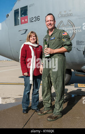 Lt. Col. Scott Wilson, un C-130 pilota in 123Airlift Wing, e sua moglie, Heather, stand da parte dell'equipaggio porta un velivolo Hercules al Kentucky Air National Guard Base in Louisville, KY., dopo che egli è stato irrorato con acqua e champagne dal suo college dopo il completamento della sua finale, o "fini", volo nov. 20, 2013. Wilson, che ha servito negli Stati Uniti Air Force e Air National Guard per 26 anni, è impostato al ritiro Gen 31, 2014. (U.S. Air National Guard foto di magg. Dale Greer) Foto Stock