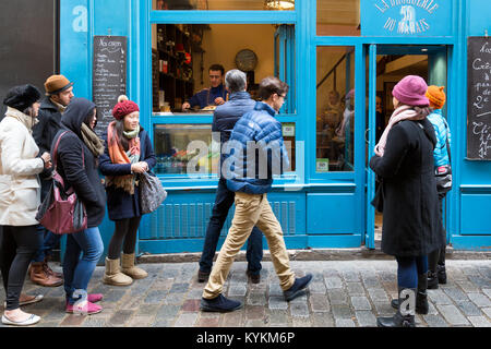 Parigi, Francia persone linea fino a comprare le crepes in una vetrina di Rue des Rossiers nel quartiere di Marais e il quartiere più antico di Parigi. Foto Stock