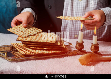 Sabato cerimonia kiddush composizione con due candele di cera in candelabri e un tradizionale Pasqua matzah fresco del pane Foto Stock