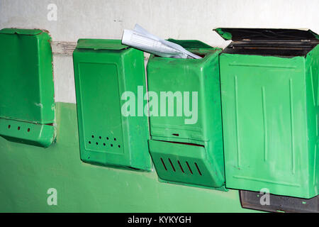 Cassette postali di colore verde sulla parete nella tromba delle scale Foto Stock