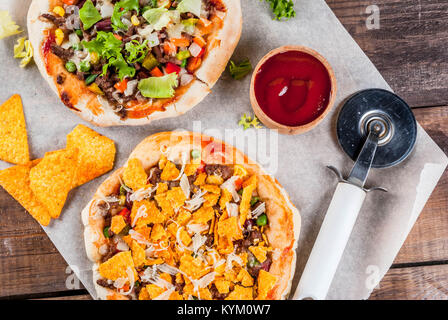 In casa Mexican Taco PIzza con Nachos chips, fagioli, verdure fresche, carni bovine, spazio di copia Foto Stock