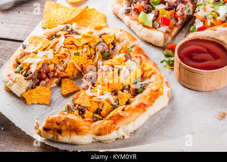 In casa Mexican Taco PIzza con Nachos chips, fagioli, verdure fresche, carni bovine, spazio di copia Foto Stock