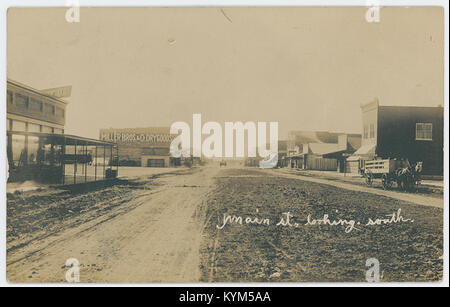 Vista su Main Street a Friona, Texas, guardando a sud. Questa immagine storica cattura l'architettura degli edifici, dei negozi e della scena stradale della metà del XX secolo, come parte di una collezione d'archivio presso la Southern Methodist University. Foto Stock