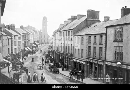 Fotografia della Lawrence Collection che mostra tre donne fuori dal municipio di Enniskillen nella contea di Fermanagh, in Irlanda, con l'iconica torre dell'orologio sullo sfondo. L'immagine, scattata all'inizio del XX secolo, cattura la vita in Irlanda del Nord all'epoca. Foto Stock