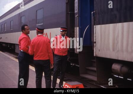 Scena sulla banchina della stazione di tre African American facchini parlando al di fuori di una carrozza del treno ingresso, Luglio, 1969. Un poggiapiedi in fondo alle scale reca il logo di CN, la Canadian National Railway. () Foto Stock