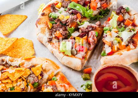 In casa Mexican Taco PIzza con Nachos chips, fagioli, verdure fresche, carni bovine, spazio di copia Foto Stock