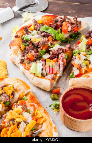 In casa Mexican Taco PIzza con Nachos chips, fagioli, verdure fresche, carni bovine, spazio di copia Foto Stock