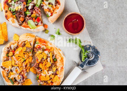 In casa Mexican Taco PIzza con Nachos chips, fagioli, verdure fresche, carni bovine, spazio copia vista superiore Foto Stock