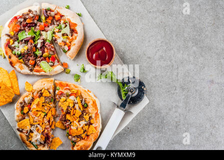 In casa Mexican Taco PIzza con Nachos chips, fagioli, verdure fresche, carni bovine, spazio copia vista superiore Foto Stock