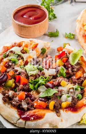 In casa Mexican Taco PIzza con Nachos chips, fagioli, verdure fresche, carni bovine, spazio di copia Foto Stock