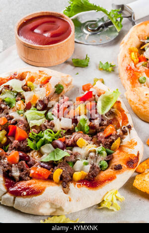 In casa Mexican Taco PIzza con Nachos chips, fagioli, verdure fresche, carni bovine, spazio di copia Foto Stock