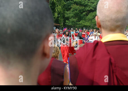 I monaci e i membri del pubblico guarda un display dei tibetani dancing at Samye Ling monastero Buddista nel sud-ovest della Scozia. Il monastero è stata fondata negli anni Sessanta da rifugiati tibetani che fuggono dalle persecuzioni nel paese nativo che si stabilirono in Scozia. Foto Stock