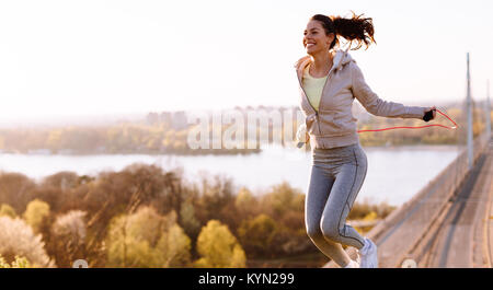 Donna attiva il salto con la corda da salto all'aperto Foto Stock