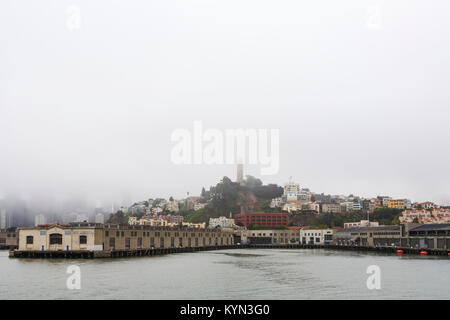 Vista del Pier 33 e dello skyline della città, terminale per Alcatraz Ferry tours e Pier 35 su un tipicamente nebbioso giorno di San Francisco, California, Stati Uniti d'America Foto Stock