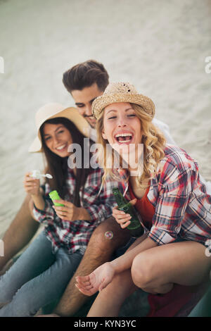 Il gruppo di allegro amici avente un grande momento in spiaggia Foto Stock