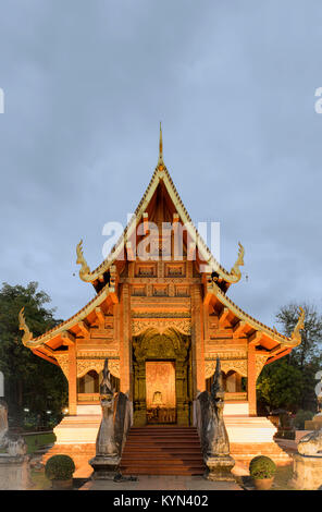 Un temle illuminato al Wat Phra Sing in Chiang Mai Thailandia su un nuvoloso e fresco Gennaio sera. Foto Stock