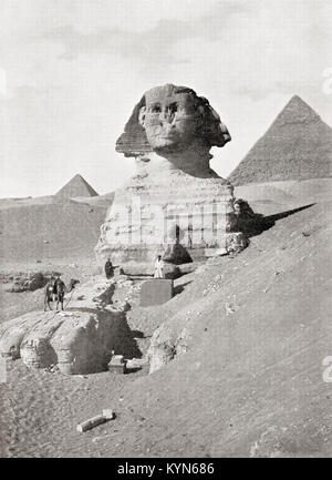 La Grande Sfinge nella Piramide di Giza complesso, altopiano di Giza, Cairo, Egitto. Un imponente scultura generalmente creduto per rappresentare il Faraone Khafre. Visto qui sono lavoratori cancellazione via la sabbia che parzializza la base del monumento. Dalle meraviglie del mondo, pubblicato c.1920. Foto Stock