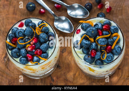 Arancione e mirtillo yogurt porridge guarnita con frutta friesh. Colazione sana idea. Foto Stock