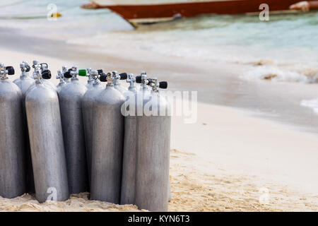 Una collezione di subacquei chiamata richiede aria su un tropicale di spiaggia di sabbia bianca. Foto Stock