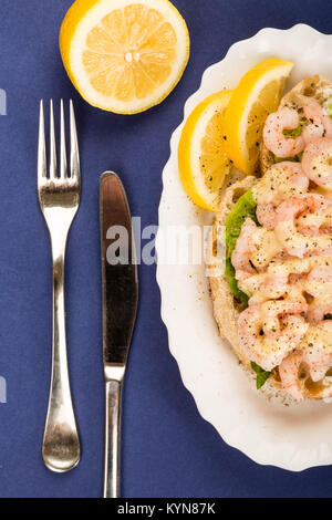 Scandinavo o stile norvegese faccia aperta gamberetti o gamberi Sandwich di pesce contro un viola o sfondo blu Foto Stock