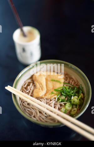 Ciotola di ramen con la sua pasta di soba e tofu e drink Amazake su un tavolo in un ristorante Giapponese, Kyoto, Giappone. Foto Stock