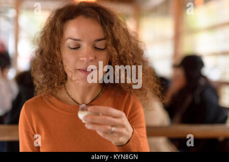 Giovane donna caucasica bere bene in un ristorante giapponese di Kyoto, Giappone Foto Stock