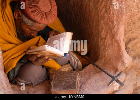 Etiopia Lalibela, chiese di roccia costruito dal re Lalibela 800 anni fa, eremita seduti nella piccola grotta della lettura della Bibbia in amarico script Foto Stock