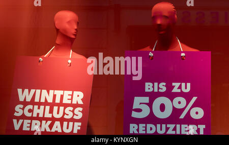 Vestito manichini portano i segni a leggere 'Winterschlussverkauf' (lit. winter sales) e "Bis zu 50% reduziert' (lit. ridotto fino al 50%) in un grande magazzino di Potsdam, Germania, 15 gennaio 2018. Foto: Ralf Hirschberger/dpa-Zentralbild/dpa Foto Stock