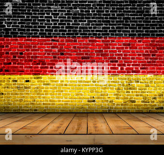 Bandiera della Germania dipinta su un muro di mattoni con pavimento in legno Foto Stock