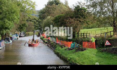 Ingegneria civile appaltatori D G Mills sta lavorando per il Canale e il fiume fiducia per ricostruire la strada alzaia parete lungo il lato del Peak Forest canal Foto Stock