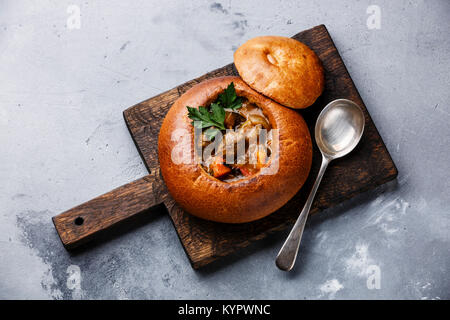 Carni bovine zuppa di carne Spezzatino in umido con patate, carote e spezie in pane su sfondo di calcestruzzo Foto Stock