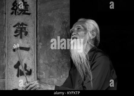 Il vecchio uomo al Thai Vi tempio, all'entrata di Ninh Binh grotta valle Trang un arruolato nell'UNESCO. Ninh Binh provincia, Vietnam Foto Stock